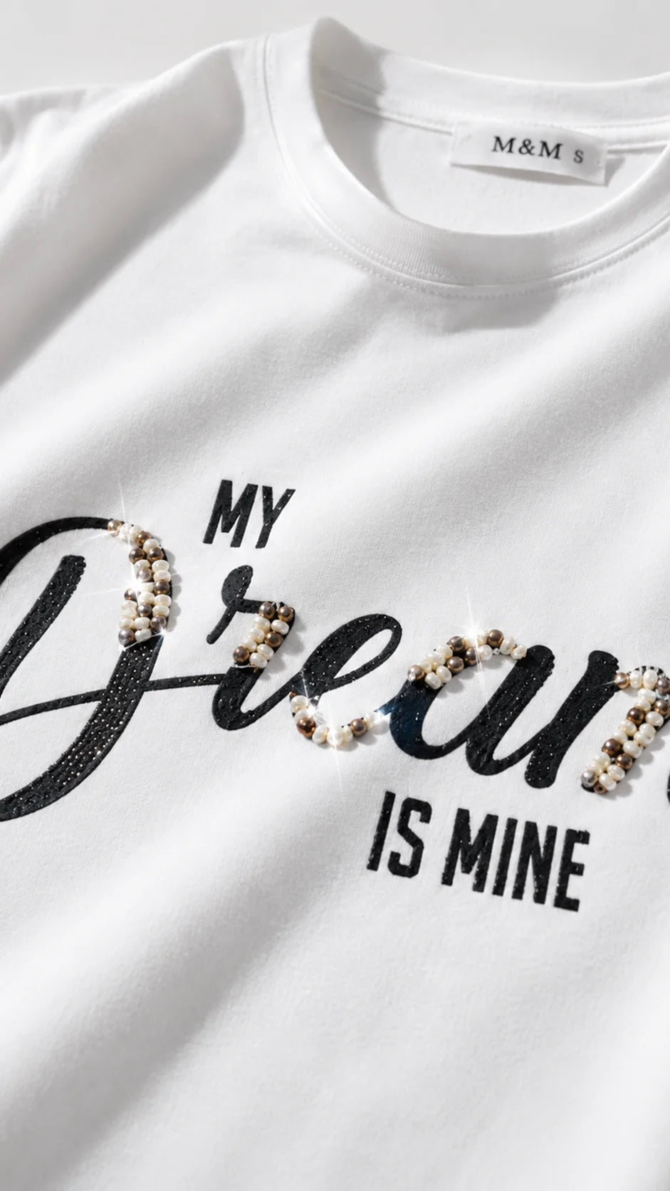 Close-up of rhinestone My Dream is Wine handwritten slogan detail on t-shirt