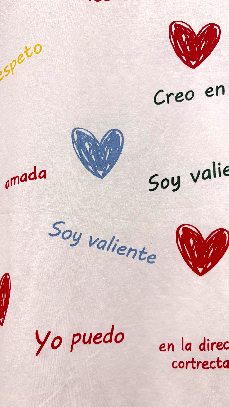 Close-up of colorful heart and positive affirmation slogan print detail on t-shirt